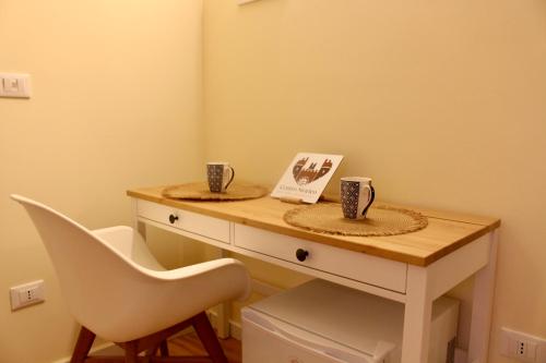 a white desk with two cups and a chair at Centro storico Bed and Breakfast in Vico del Gargano
