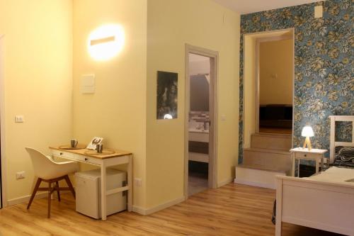 a room with a desk and a hallway with stairs at Centro storico Bed and Breakfast in Vico del Gargano