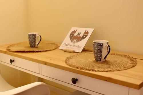 two cups on a counter with a box on it at Centro storico Bed and Breakfast in Vico del Gargano