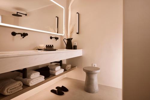 a bathroom with a sink and a mirror and towels at Windmill Karamitsos since 1859 in Tripití
