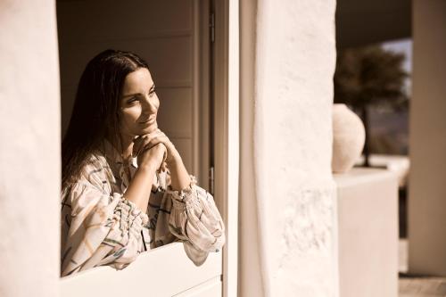 a woman looking in a window at Windmill Karamitsos since 1859 in Tripití