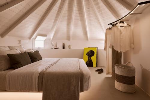 a bedroom with a bed and a white ceiling at Windmill Karamitsos since 1859 in Tripití