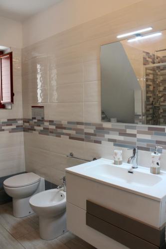a bathroom with a sink and a toilet and a mirror at Centro storico Bed and Breakfast in Vico del Gargano