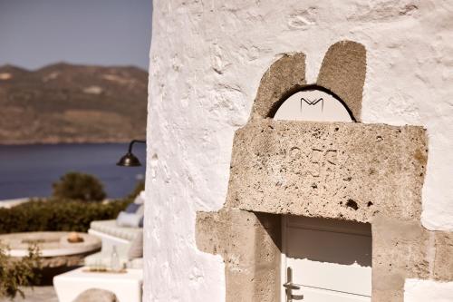 a building with a door with a face on it at Windmill Karamitsos since 1859 in Tripití