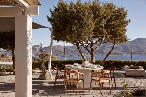 a table and chairs on a patio with a view of the water at Windmill Karamitsos since 1859 in Tripití