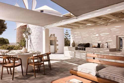 a patio with a table and chairs and a kitchen at Windmill Karamitsos since 1859 in Tripití