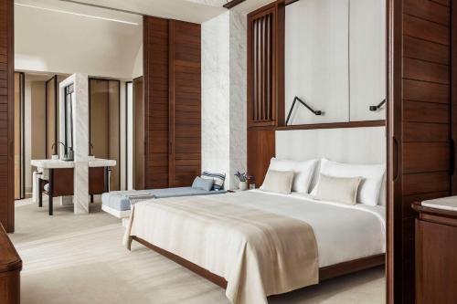 a bedroom with a large bed and a bathroom at One&Only Kéa Island in Pisses