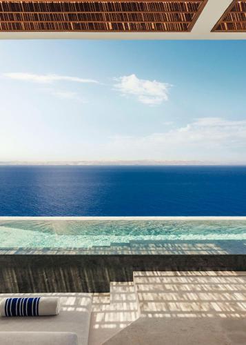 a swimming pool with a view of the ocean at One&Only Kéa Island in Pisses