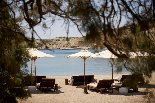 a group of chairs and umbrellas on a beach at One&Only Kéa Island in Pisses