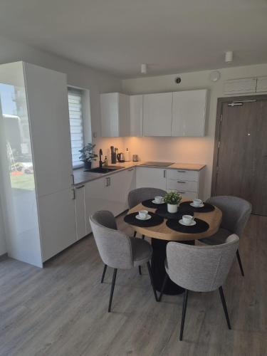 a kitchen with a table and chairs in a room at Sonia Pearl Apartament z parkingiem in Sianozety