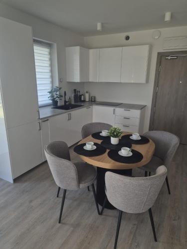 a kitchen with a table and chairs in a kitchen at Sonia Pearl Apartament z parkingiem in Sianozety