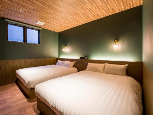 two beds in a room with green walls at Rakuten STAY VILLA Nasu in Nasu