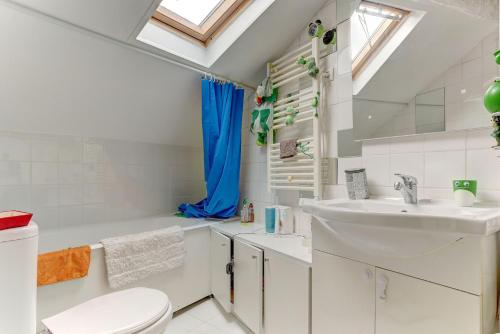 a white bathroom with a sink and a toilet at Le Versaillais in Le Chesnay