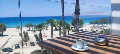 a table with a cup of coffee on top of a beach at Irene Studios in Mastichari