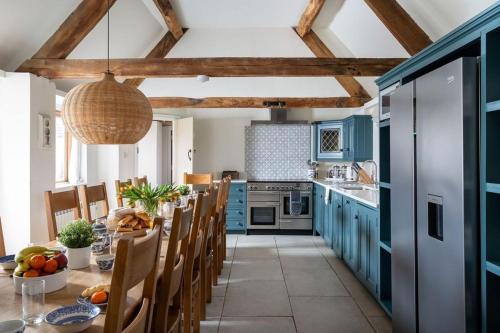 a kitchen with blue cabinets and a table and chairs at Broadway House, 7 Bedroom, 6 Baths in Cheltenham