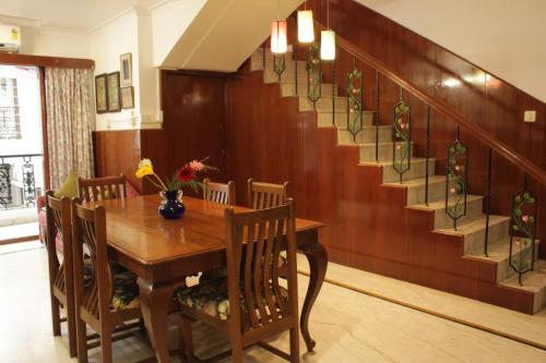 a dining room with a table and a staircase at Happy Planet in Chennai