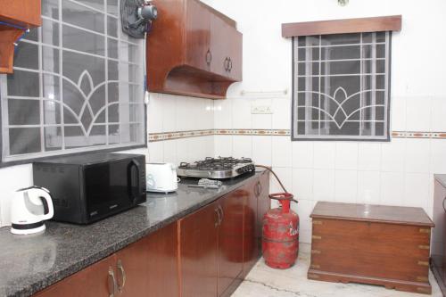 a kitchen with a stove and a microwave on a counter at Happy Planet in Chennai
