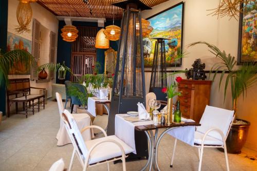 a restaurant with white chairs and tables in a room at La Varangue in Antananarivo