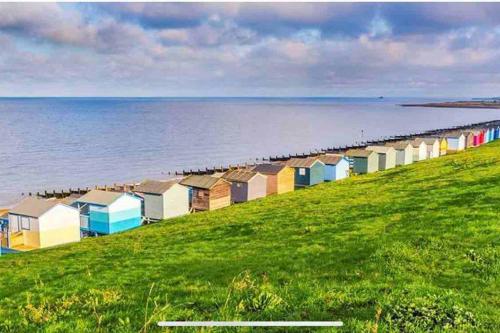 a row of beach huts on the shore of the water at Herne Bay Central - 2 minutes from beach apartment in Herne Bay