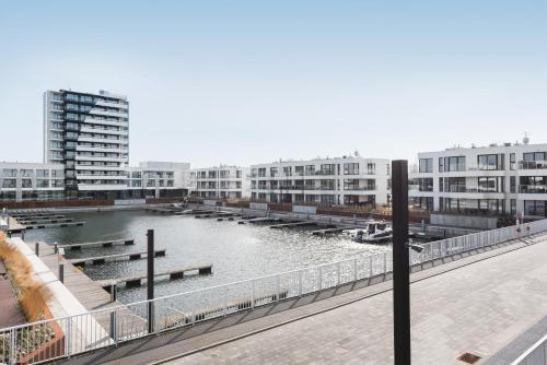 a body of water with buildings and boats in it at Sol Marina Resort Wyspa Sobieszewska II - LoftAffair Collection in Wiślinka