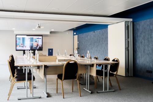a conference room with a long table and chairs at Hôtel Best of Both - Divonne-les-Bains in Divonne-les-Bains
