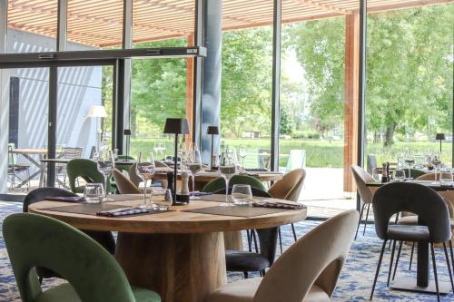 - une salle à manger avec des tables, des chaises et des fenêtres dans l'établissement Best of Both, à Divonne-les-Bains