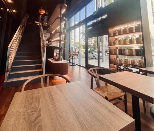 a restaurant with wooden tables and chairs and a staircase at Smart Brickell Hotel in Miami