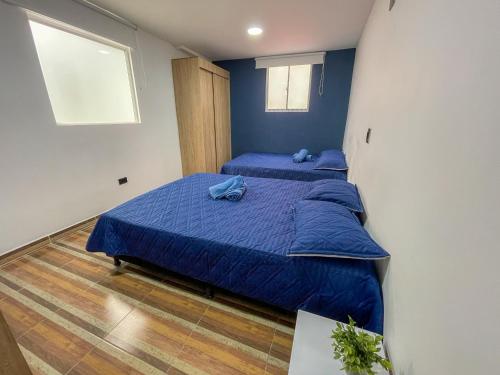 a bedroom with two beds with blue sheets and a window at Coliving Casa encanto, Apartamento - Habitaciones, Laureles-América in Medellín