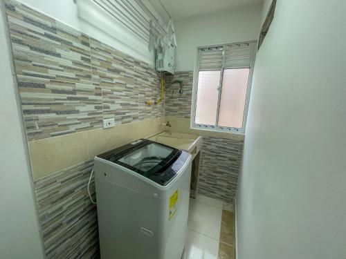 a small bathroom with a trash can and a brick wall at Coliving Casa encanto, Apartamento - Habitaciones, Laureles-América in Medellín