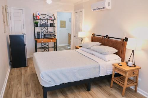 a bedroom with a bed and a table and a refrigerator at Cozy Studio - Walk to the Beach! in Jacksonville Beach