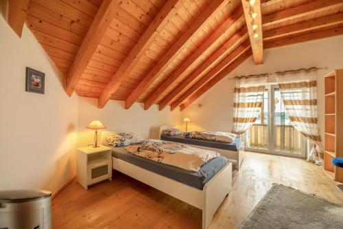 a bedroom with two beds and a wooden ceiling at Haus Emanuel in Weilerbach