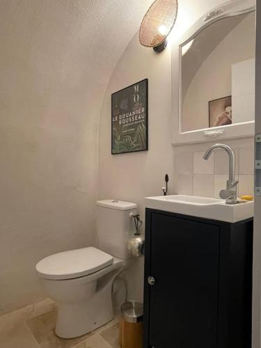 une salle de bain avec toilettes, lavabo et miroir dans l'établissement Petit havre de paix en pleine nature cévenole, à Monoblet