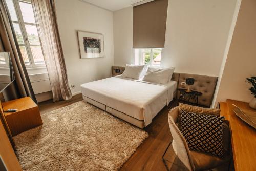 a bedroom with a bed and a table and a chair at Hotel Gredič in Dobrovo