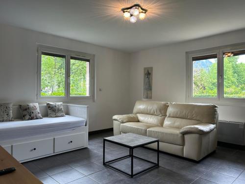 un salon avec un canapé et une table dans l'établissement Écrin des Iris, au Bourg-dʼOisans