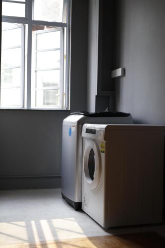 a washing machine in a room with a window at BEAT. Capsule Hostel @ Boat Quay in Singapore