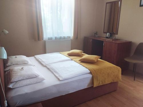a bedroom with a bed with towels on it at Stan és Panzió in Balatonalmádi