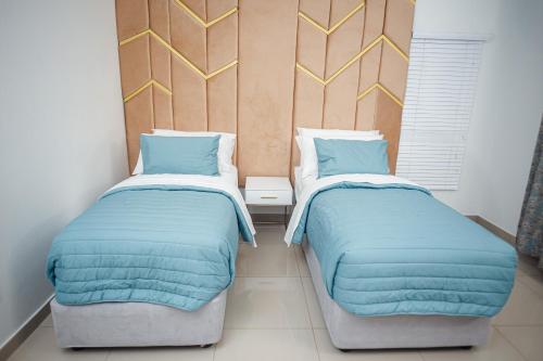 two beds sitting next to each other in a room at Shobalenku Opulent apartments in Mbabane