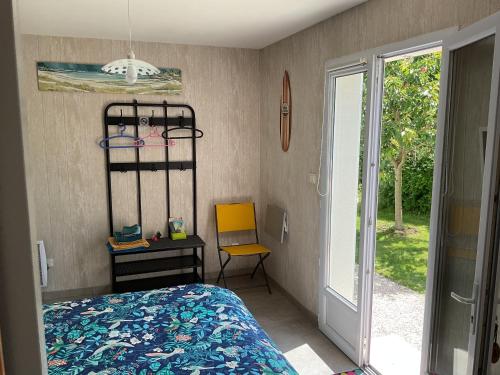 Un dormitorio con una cama y una silla y una ventana. en Les Lavatères, en Hiers-Brouage
