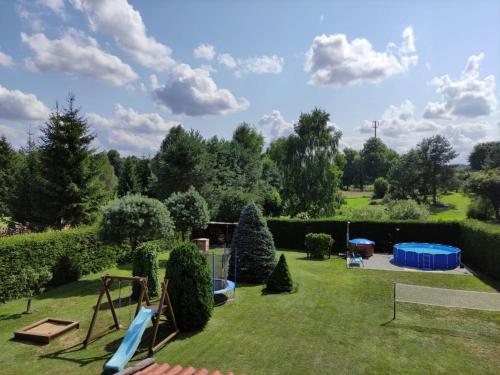 a garden with a slide and a playground at Dom pod gwiazdami in Gamerki Wielkie