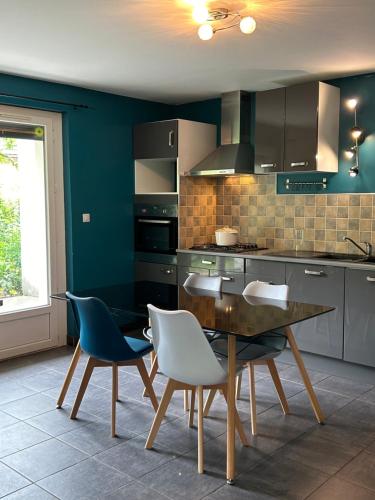 une cuisine avec une table et des chaises dans une pièce dans l'établissement Écrin des Iris, au Bourg-dʼOisans