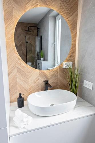 a bathroom with a white sink and a mirror at Apartament Ponidzie in Zbludowice