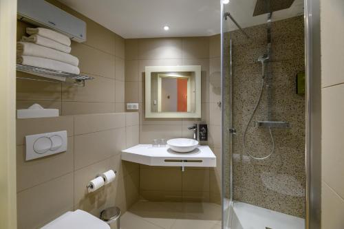 a bathroom with a shower and a toilet and a sink at Best Western Plus Ajaccio Amirauté in Ajaccio