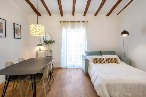 Vintage & Modern Old Town Alcoy في الكوي: غرفة نوم بسرير وطاولة طعام