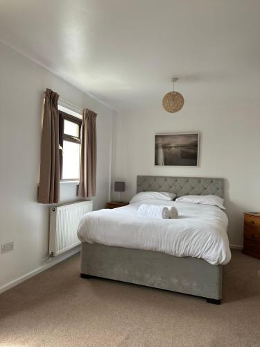 a bedroom with a large bed and a window at Wheal Frances-Beautifully Fitted Bungalow Helston Cornwall in Helston