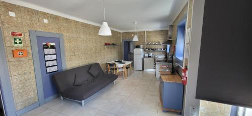 a living room with a couch and a kitchen at Oliver's place Guesthouse in Casal Pereiro