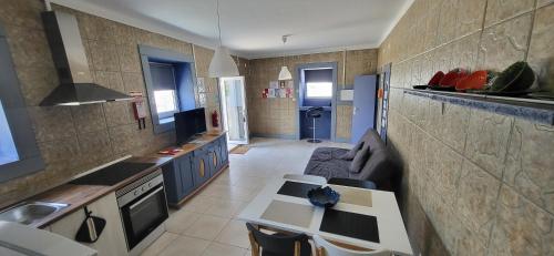 a kitchen with a couch and a table in it at Oliver's place Guesthouse in Casal Pereiro