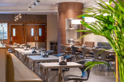 a row of tables and chairs in a restaurant at Premier Inn Abu Dhabi Airport Business Park in Abu Dhabi