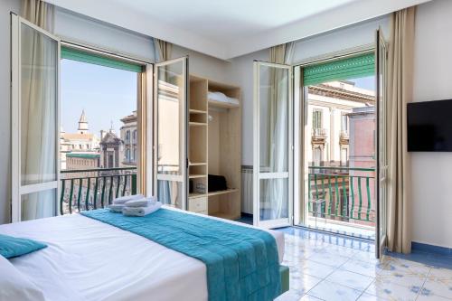 a bedroom with a large bed and a balcony at Napolit'amo Hotel Medina in Naples