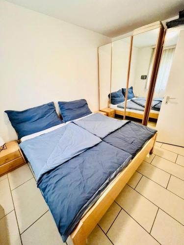 a bedroom with a bed with blue sheets and a mirror at Mon Bijoux in Ascona