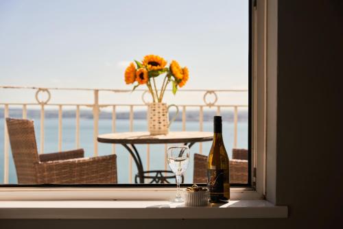 uma mesa com uma garrafa de vinho e um copo em Bayfort Sea Studio - Comfortable Couples Retreat with Stunning Coastal Views em Torquay